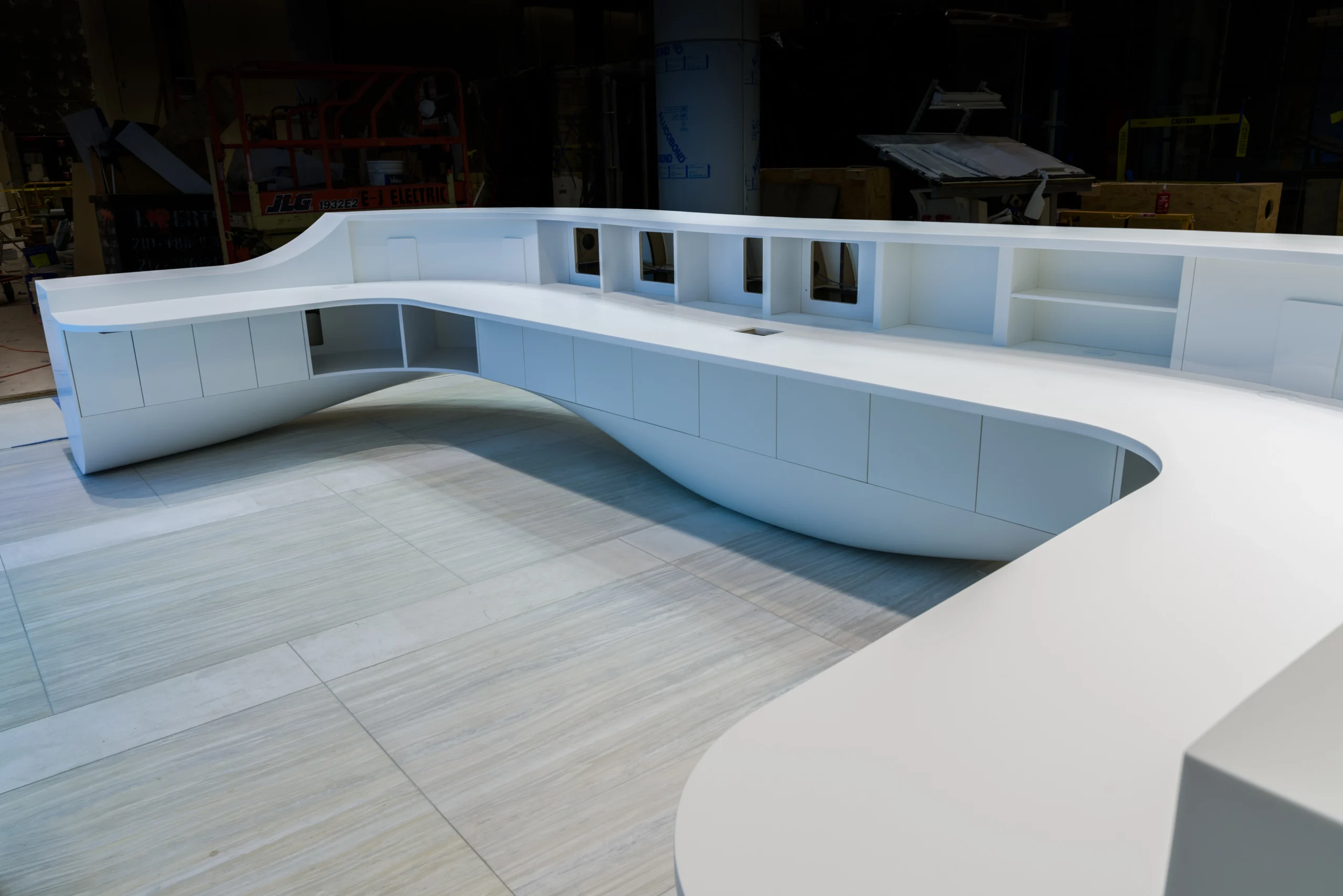 A white curved desk with shelves.