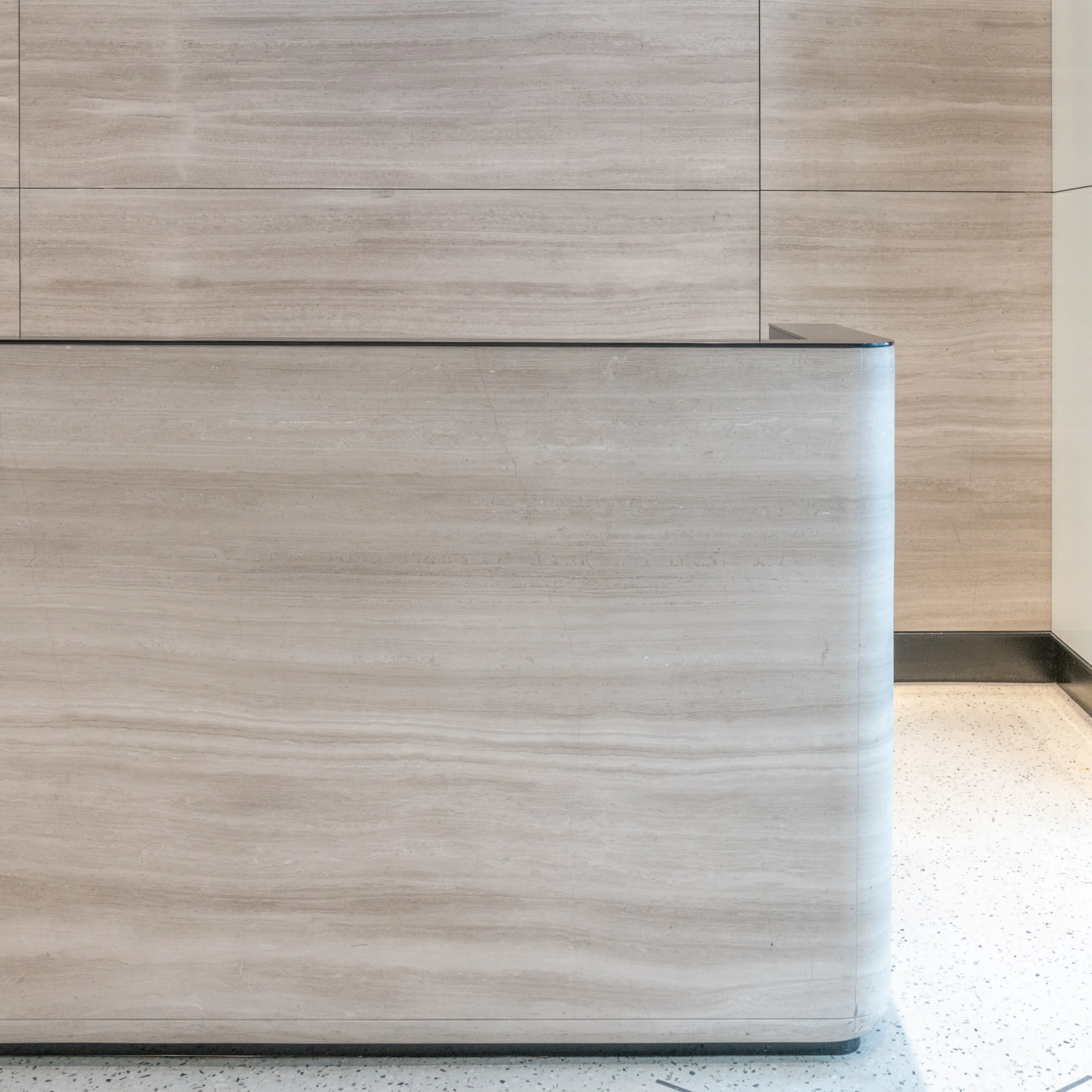 A Stone and steel reception desk in a stone room